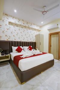 a bedroom with a large bed with red and white pillows at MAXX Elite in Gurgaon +94 photos