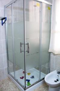 y baño con ducha y puerta de cristal. en Apartamento Luceros, en Alicante