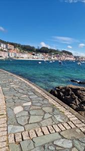 a cobblestone walkway next to the ocean with a city at Apartamento Raxobrisamar in Raxó