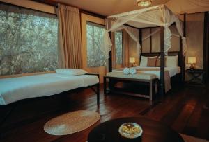 a bedroom with two beds and a canopy bed at Chena Wilds Wilpattu in Horuwila +5 photos
