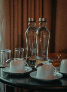 two glass bottles on a table with plates and glasses at Chena Wilds Wilpattu in Horuwila