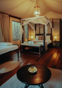 a bedroom with a bed and a table in a room at Chena Wilds Wilpattu in Horuwila