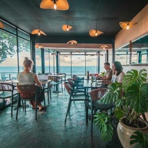a group of people sitting at tables in a restaurant at Northern Cove Penang in Tanjung Bungah