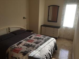 a bedroom with a bed and a dresser and a mirror at Playa Los Locos - Coloso in Torrevieja