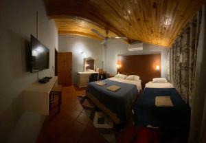 a hotel room with two beds and a television at Hotel Solares in Barrio Caacupé Mí