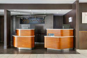 a lobby with wooden counters in a building at Courtyard Atlanta Suwanee in Suwanee +42 photos