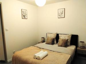 a bedroom with a bed with two towels on it at Ô Bon Goût in Bourges