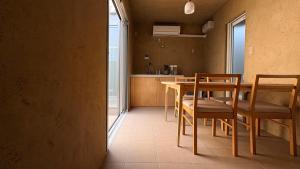 a kitchen with a table and chairs in a room at トシマトビ in Toshima
