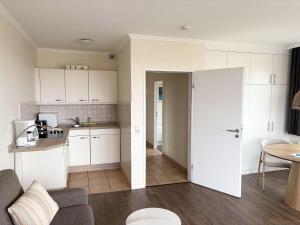 a kitchen and living room with white cabinets at Germania-60 in Böhl