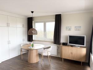 a living room with a table and a tv at Germania-60 in Böhl