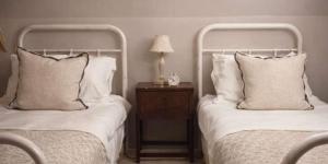 two beds sitting next to each other in a bedroom at Jasmine Cottage, Upper Slaughter, Cotswolds in Cheltenham