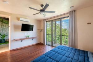 a bedroom with a blue bed and a large window at Master Jungle Penthouse with Large Private Terrace - Santuario Hotel Boutique in Chemuyil