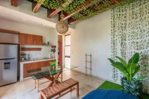 a living room with a glass table and a kitchen at Master Jungle Penthouse with Large Private Terrace - Santuario Hotel Boutique in Chemuyil