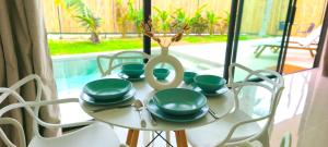 a table with green dishes and a vase on it at Samma Villas - Agate Villa - 1 BDR & private pool in Ko Phangan