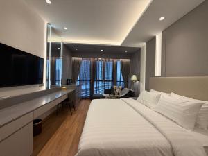 a bedroom with a large bed and a desk with a television at The Aerie in Kuala Lumpur
