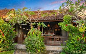 a house with a porch with trees and bushes at Sirya Farm House in Meliling +10 photos