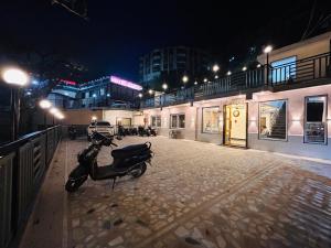 a motor scooter parked on a street at night at Oakleaf Hotel & Resort - A Classic Rooms & Prime Location Near Library Chowk in Mussoorie