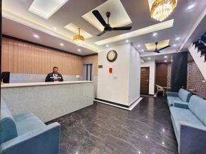 a man standing at a counter in a lobby at Oakleaf Hotel & Resort - A Classic Rooms & Prime Location Near Library Chowk in Mussoorie