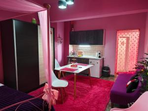 a kitchen with a pink room with a table at Barbie in Veria