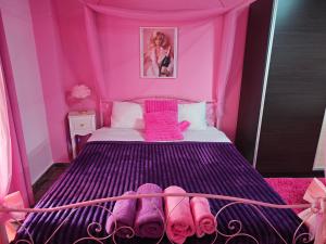 a pink bedroom with a bed with pink towels on it at Barbie in Veria