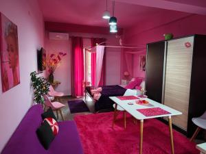 a purple living room with a table and a couch at Barbie in Veria