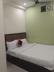 a bedroom with a bed with a book on it at Hotel Ayodhya in Ayodhya +17 photos