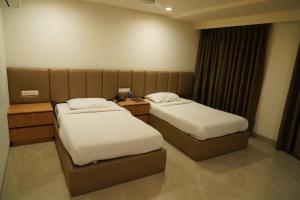 a hotel room with two beds and a window at Hotel Shubham Prestige in Surūrnagar