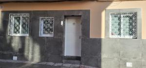 a white door and two windows on a building at Casa del Pilar in Pinto