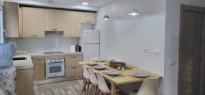 a kitchen with a table with chairs and a white refrigerator at Casa del Pilar in Pinto