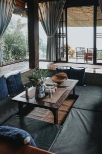 a living room with a table and a couch at Baan Mon Muan in Mon Jam