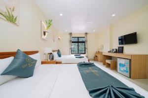 a bedroom with a large white bed with blue pillows at Cat Ba Flora Hotel in Cat Ba