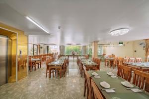 a dining room with wooden tables and chairs at Cat Ba Flora Hotel in Cat Ba