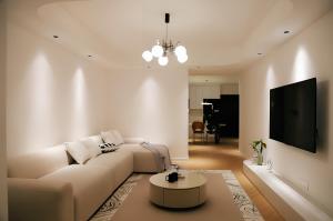 a white living room with a couch and a tv at Merit黄浦 Bright and Modern 2Bed Condo unit in downtown Shanghai in Shanghai