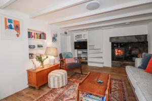 a living room with a couch and a fireplace at Ivy Cottage in Tintagel