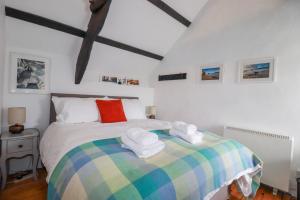 a bedroom with a bed with towels on it at Ivy Cottage in Tintagel