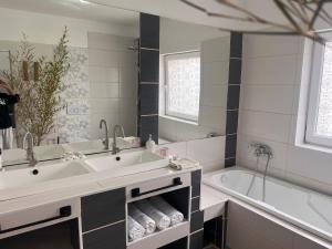 a bathroom with a large sink and a tub at Ladislaus Garden Suites in Cegléd +118 photos