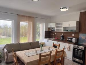 a kitchen and living room with a table and a couch at Ladislaus Garden Suites in Cegléd