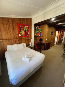 a bedroom with a bed with a towel on it at Bunkhouse Motel Cooma in Cooma