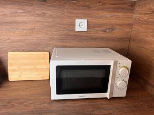 a microwave sitting on top of a wooden table at Ladislaus Garden Suites in Cegléd