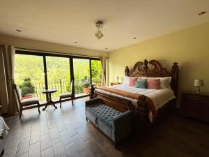 a bedroom with a large bed and a large window at Hotel y Restaurante Vista Verde in Santa Lucía Milpas Altas