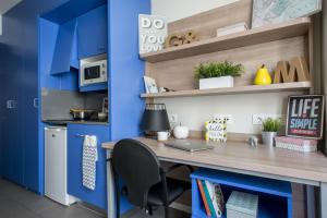 ein Büro mit blauen Wänden und einem Schreibtisch mit einem Laptop in der Unterkunft Colegio Mayor La Concepción in Valencia