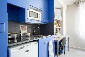 cocina azul con fregadero y microondas en Colegio Mayor La Concepción en Valencia