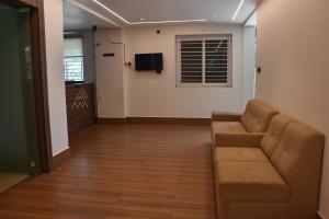 a living room with a couch and a television at Bihotels And Resorts in Yercaud +40 photos