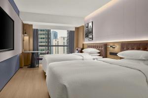 a row of beds in a hotel room with a tv at Four Points by Sheraton Chongqing in Chongqing +112 photos