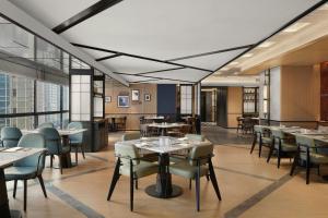 a dining room with tables and chairs and windows at Four Points by Sheraton Chongqing in Chongqing
