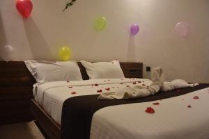 a bedroom with balloons and a bed with roses on it at Bihotels And Resorts in Yercaud
