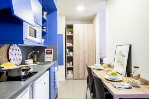 eine Küche mit blauen Wänden und einem Tisch mit Geschirr darauf in der Unterkunft Colegio Mayor La Concepción in Valencia