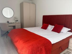 a bedroom with a large bed with a red blanket at IDDA Concept 3 in Târgu-Mureş