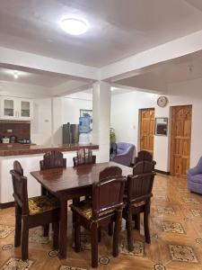 a kitchen and dining room with a wooden table and chairs at Mabel's Garden Stay in Puerto Galera