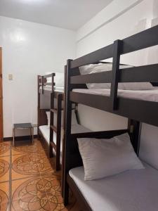 a group of bunk beds in a room at Mabel's Garden Stay in Puerto Galera
